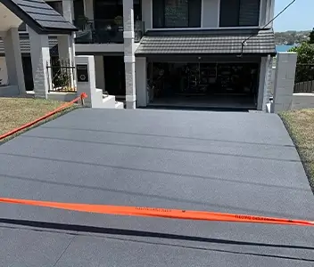 Newly poured charcoal concrete driveway for a modern residence in Newcastle