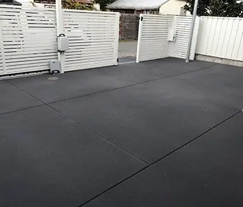 Seamless dark concrete patio slab behind a residential garden gate