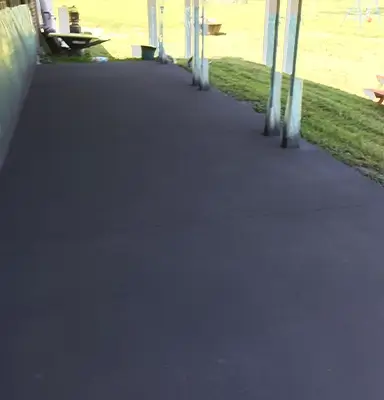 Dark smooth concrete resurfacing for an outdoor entertaining space in Newcastle